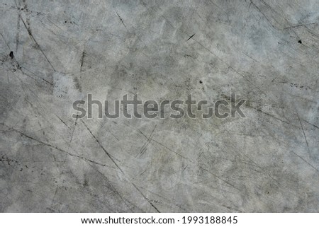 The background of the gray concrete floor is exhausted by black stripes.