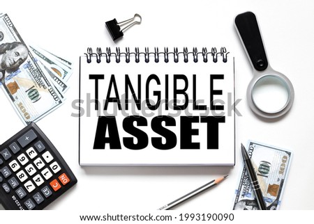 Tangible Asset. notebook on white workspace. near the notepad dollar bills and a calculator Royalty-Free Stock Photo #1993190090