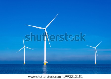 offshore windmill park with clouds and a blue sky, windmill park in the ocean aerial view with wind turbine Flevoland Netherlands Ijsselmeer. Green energy  Royalty-Free Stock Photo #1993213151