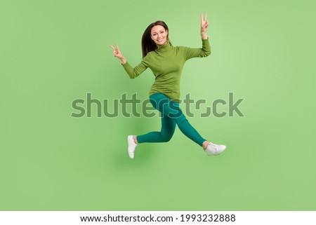 Full length body size photo woman jumping up showing v-sign gesture isolated pastel pink color background