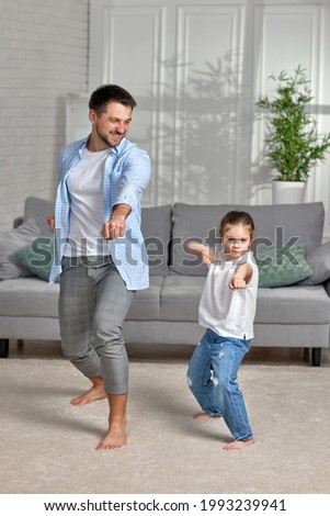 father and his cute little daughter train at home. Royalty-Free Stock Photo #1993239941