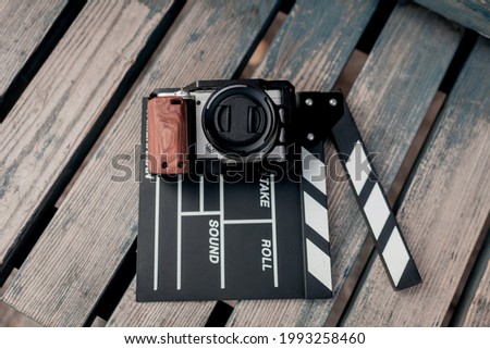 Vintage image - camera and movie clapper on wooden background