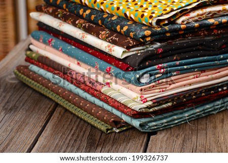 heap of cloth fabrics on wooden table