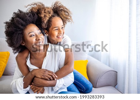 Loving young mother laughing embracing smiling cute funny kid daughter enjoying time together at home, happy family single mom with little child girl having fun playing feel joy cuddling and hugging