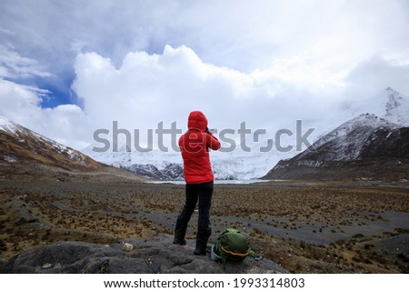 Woman photographer taking pictures in winter high altitude mountains