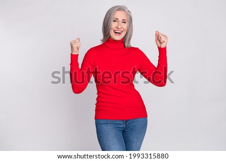 Photo of cheerful elderly woman happy positive smile rejoice victory success fists hands isolated over grey color background