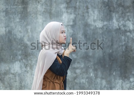Beautiful young asian muslim shut up sign