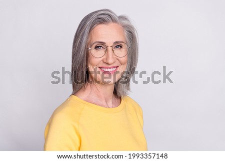 Portrait of happy cheerful smiling mature woman beaming after stomatology treatment isolated on grey color background