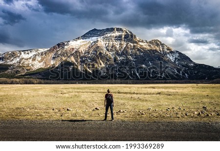 An epic shot of a hiker in front of a mountain Royalty-Free Stock Photo #1993369289