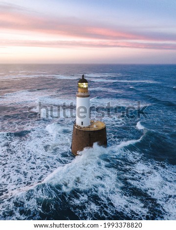 Waves hitting a lighthouse in Scotland Royalty-Free Stock Photo #1993378820