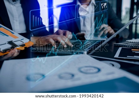 Double exposure of business teamwork or business partners discussing and meeting at the modern office desk, Innovation financial graphs interfaces, Workplace strategy concept, blurred background.