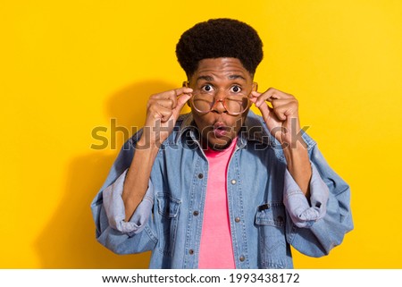 Photo of young shocked afro american man hold hands wear glasses news isolated on yellow color background