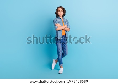 Full length photo of young school boy serious confident crossed hands isolated over blue color background Royalty-Free Stock Photo #1993438589