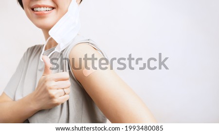 COVID-19 vaccination concept. A beautiful asian woman smiling and doing thumbs up after getting a Vaccine feeling okay and no side effect. Herd Immunity, Vaccinated, Protect, Hospital, Advertising Royalty-Free Stock Photo #1993480085