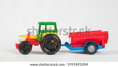 Plastic toy multicolored cars isolated on white background. Tractor with a trailer.