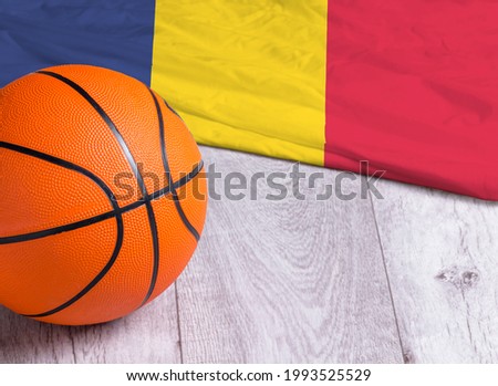 Orange basketball ball with flag Romania on wooden parquet. Close-up image of basketball ball over floor in the gym. Basketball championship concept