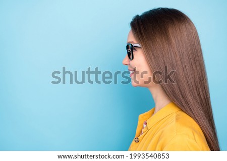 Profile side photo of young cheerful girl happy positive smile look empty space confident isolated over blue color background