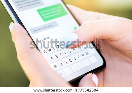 Text message with mobile phone. Woman texting sms with smartphone Catfish or digital scam. Screen keyboard in instant messaging chat. Macro close up of finger writing. Conversation with boyfriend. Royalty-Free Stock Photo #1993542584