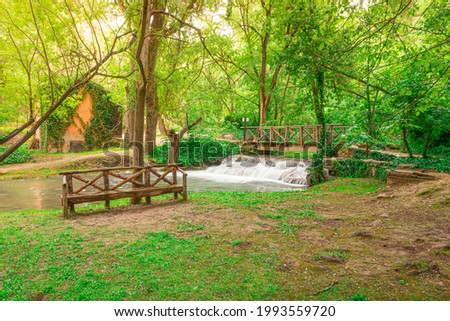 Beautiful picture of "Monasterio de Piedra" (Stone Monastery) natural park. Green idyllic forest with a wood bench and a river.