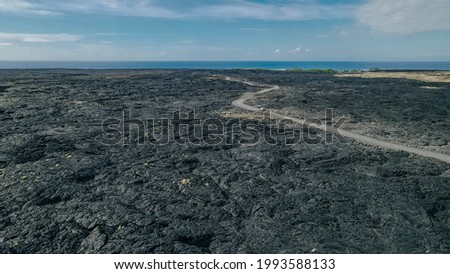 Chain of Craters Road in Hawaii Volcanoes National Park is vivid with blue ocean, waves and black sea cliffs. Cliffs were formed when Mauna Ulu exploded liquid lava.