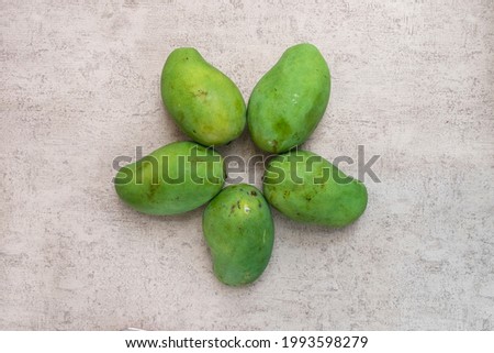 Bunch of green mango star shape formed on grey background