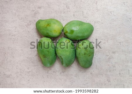 Bunch of green mango square formed on grey background