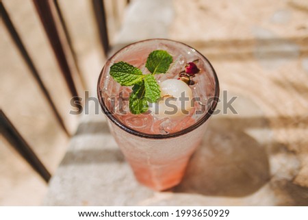 Lychee Pink Rose Italian Soda in transparent glass decorated with Mint leaves.