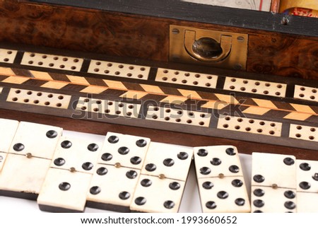 An antique wooden games box. Including chess, dominos, checkers and playing cards.