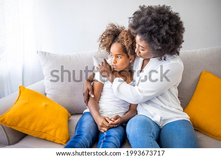 Worried young foster care parent mother comforting solacing embrace adopted little child daughter give care and protection at home, loving concerned adult mom hug sad small girl consoling kid concept