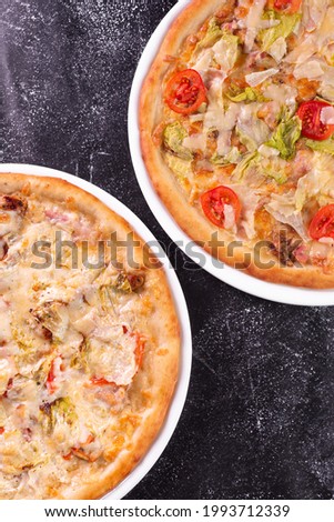 two pizzas are stone table on the kitchen top view