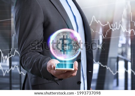 Businessman holds an illustration of bitcoin in his hand in the background