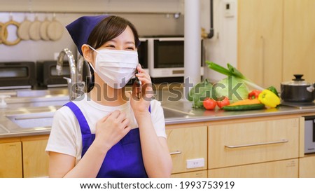 Searching for recipes on your smartphone A masked female housekeeper