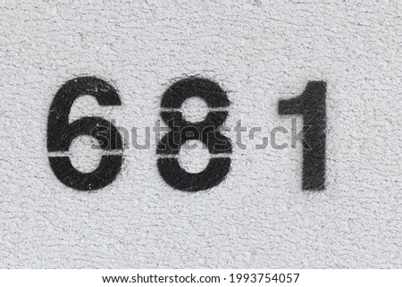 Black Number 681 on the white wall. Spray paint. Number six hundred and eighty one.