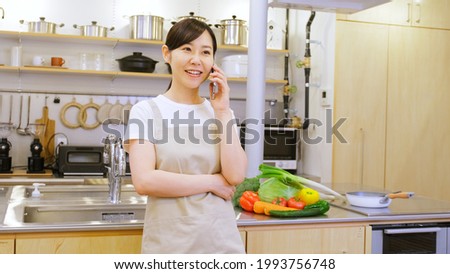 Female worker on behalf of housework talking on a smartphone