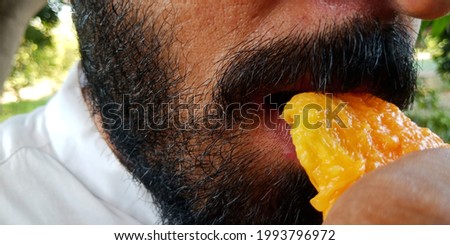 The man is eating mango, close up views