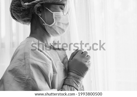 Black and White tone of healthcare worker praying for god blessing while working in hospital during coivd-19 pandemic. Conceptual of woman praying for god to help everythings will be better. Royalty-Free Stock Photo #1993800500