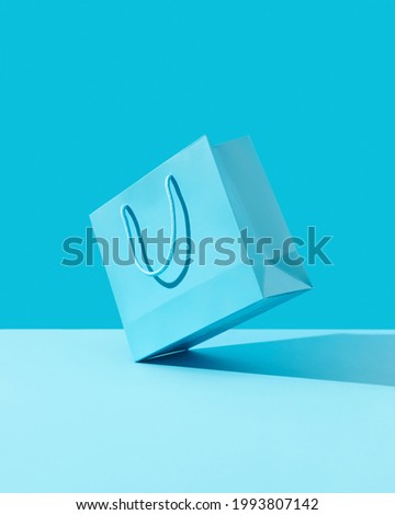 Paper shopping bag on blue background. Shopping sale delivery concept Royalty-Free Stock Photo #1993807142
