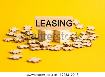 LEASING. puzzles and wooden cubes with the text on a YELLOW background. Concept for management and business.