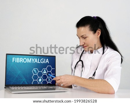  FIBROMYALGIA text in menu. Oncologist looking for something at laptop
