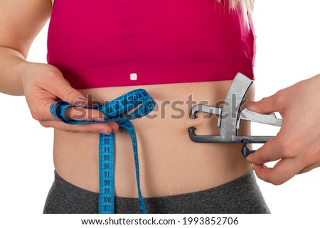 Picture of a woman measuring her body fat, on isolated background