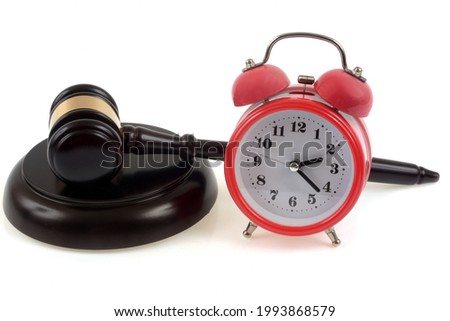 Judge's gavel on its plinth next to a bell clock in close-up on white background Royalty-Free Stock Photo #1993868579