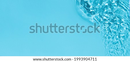 Transparent blue clear water surface texture with ripples, splashes and bubbles. Abstract summer banner background Water waves in sunlight with copy space Cosmetic moisturizer micellar toner emulsion Royalty-Free Stock Photo #1993904711