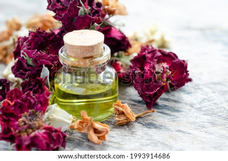 Closed up dry flower essential oil in glass bottle over blur dry rose, and jasmine flower on grunge background