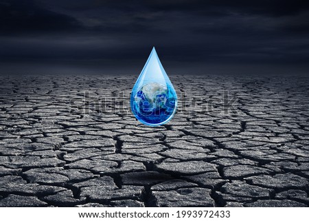 Ecology and Environmental Concept : Blue planet earth in water drop with cracked brown ground in background. (Elements of this image furnished by NASA.)