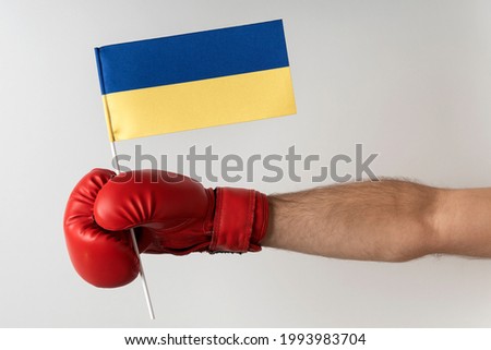 Boxing glove with Ukrainian flag. Boxer holds flag of Ukraine. White background