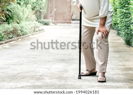 Elderly woman Standing on the street she is having symptoms Pain on both sides of the knee, due to osteoporosis, to retirement age and health care concept. Royalty-Free Stock Photo #1994026181