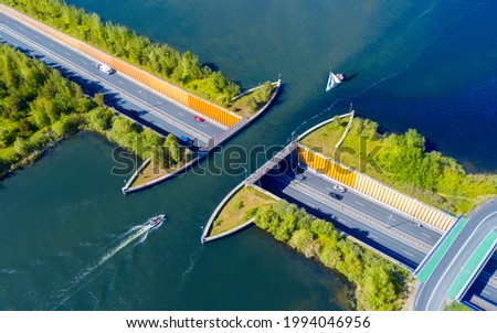 Aquaduct Veluwemeer, Nederland. Aerial view from the drone. A sailboat sails through the aqueduct on the lake above the highway. Royalty-Free Stock Photo #1994046956