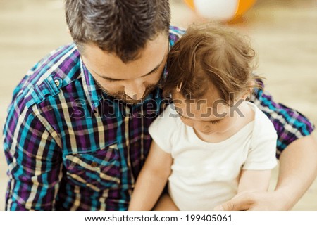 happy father and his little daughter playing at home