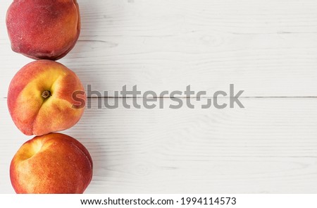 Fresh juicy peaches, layout on a white wooden table. Top view, idea for a banner or mockup for advertising fresh fruits from the farm