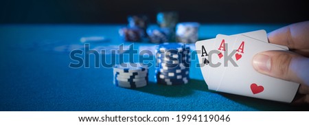 Hand picks up cards, three aces, plays casino poker. Background with copy space Royalty-Free Stock Photo #1994119046